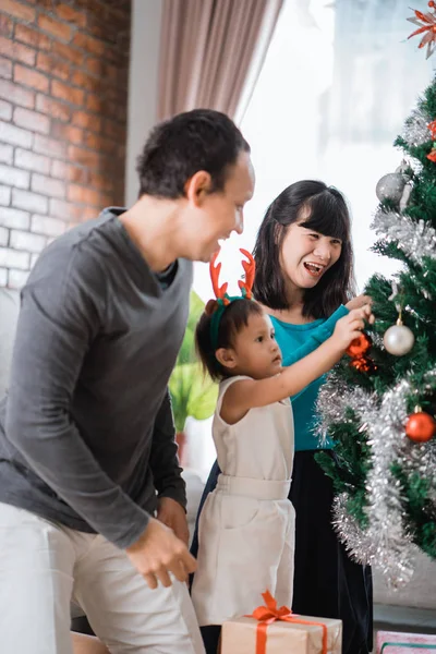 Retrato de membros da família definir uma árvore de Natal — Fotografia de Stock