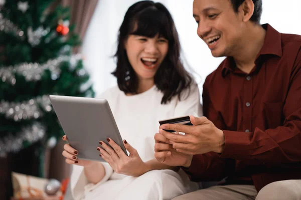 happy young couple buying stuff online using credit card