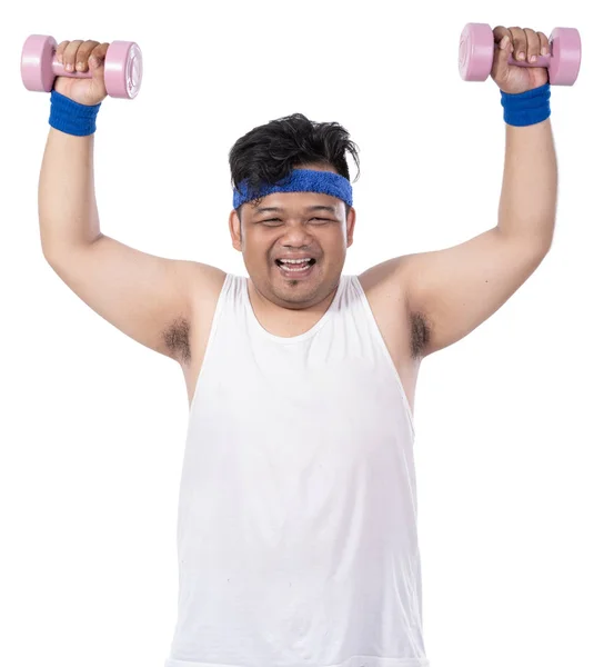 Portrait of fat young toothy man doing exercise with arms lift dumbbells — Stock Photo, Image