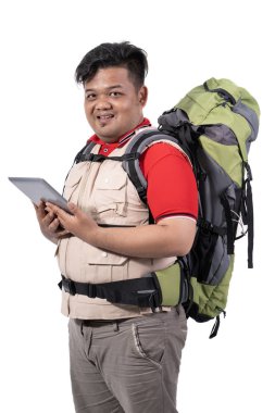 Genç adam backpacker ayakta tutan dijital tablet portresi