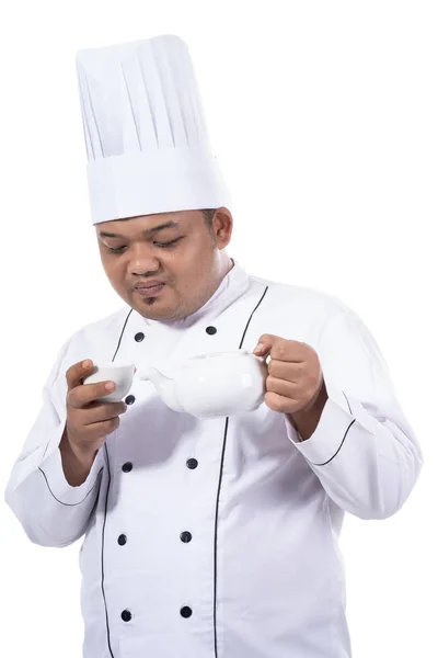 Retrato de joven chef verter té a la taza — Foto de Stock