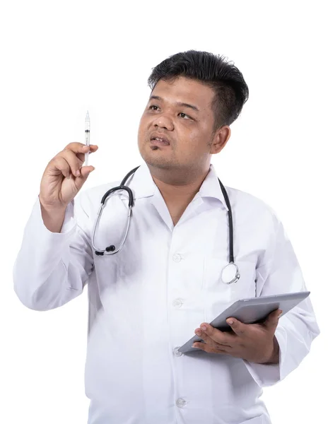 Retrato de un médico serio que sostiene una inyección y una lengüeta — Foto de Stock