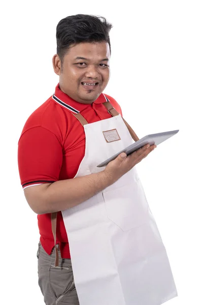 Porträt eines jungen Schneiders mit Schürze und digitalem Tablet — Stockfoto