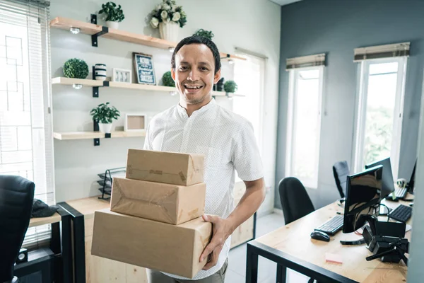 Porträtt av asiatisk ung man transporterar paket — Stockfoto