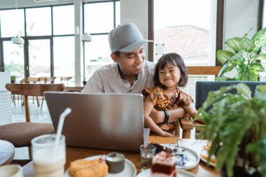 Baba kızıyla dizüstü bilgisayar kullanarak