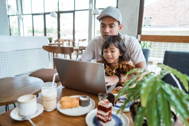 Baba ile kızı kucağında oturan
