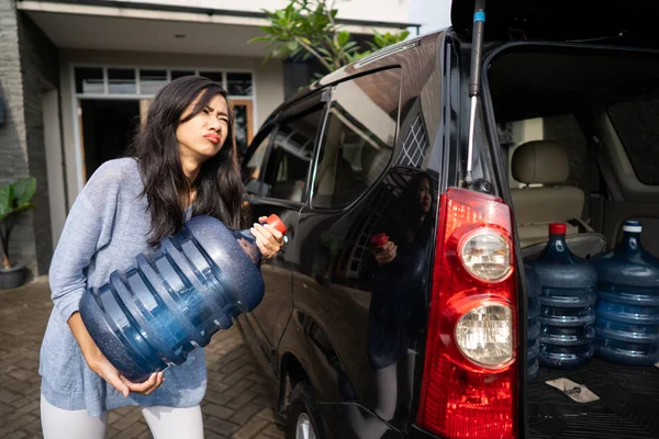 Mulher infeliz carregando um galão de água — Fotografia de Stock