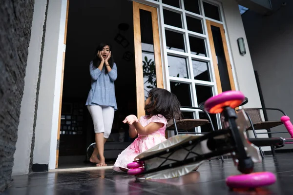 Impactado mamá mirando a su hija cayó de scooter — Foto de Stock