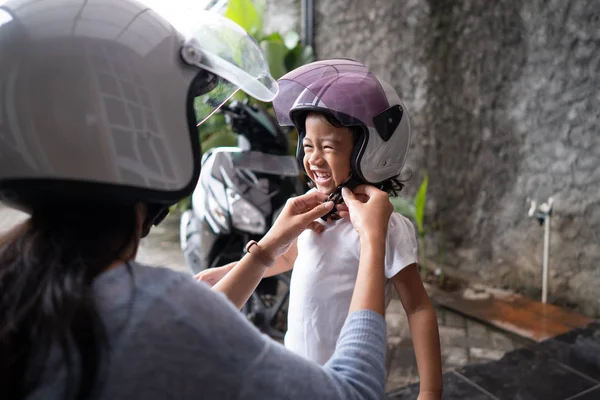 Anne çocuğunu bir kask koymak için yardım — Stok fotoğraf