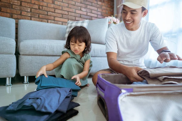 Segítve fel ruhák a bőrönd apja lánya — Stock Fotó