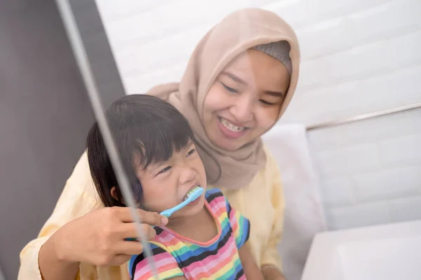 Madre y su hija cepillándose los dientes —  Fotos de Stock