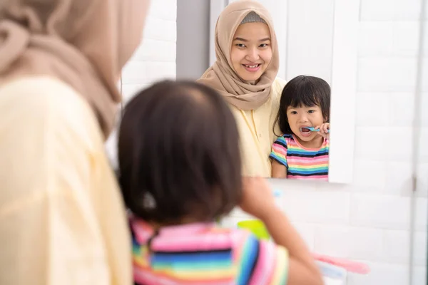 Madre y su hija cepillándose los dientes — Foto de Stock