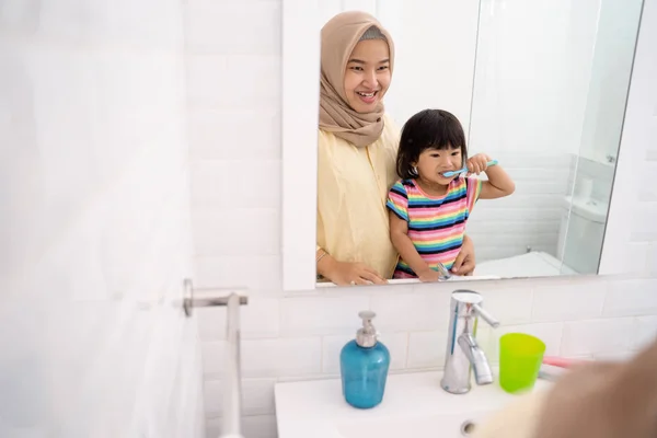 Мати і її дочка чистять зуби — стокове фото
