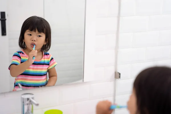 Retrato de una niña muy inteligente cepillarse los dientes es una actividad rutinaria —  Fotos de Stock