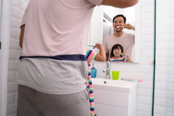 Pai e menina escovar os dentes juntos — Fotografia de Stock