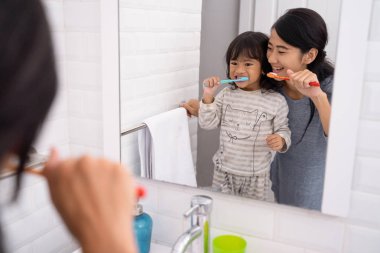 Anne ve kızı banyoda diş fırçalama lavabo