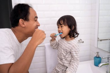 Baba ve kızı birlikte diş fırçalama