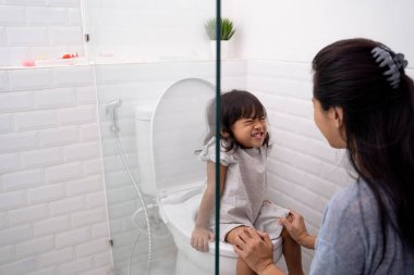 anne çocuğunu tuvaleti kullanmak için yardım