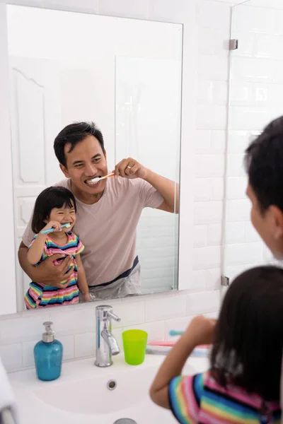 Батько і дочка чистять зуби разом — стокове фото