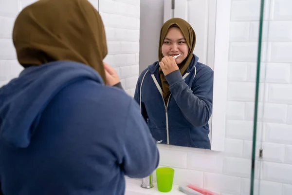 女性はヒジャーブを着て彼女の歯を磨く — ストック写真