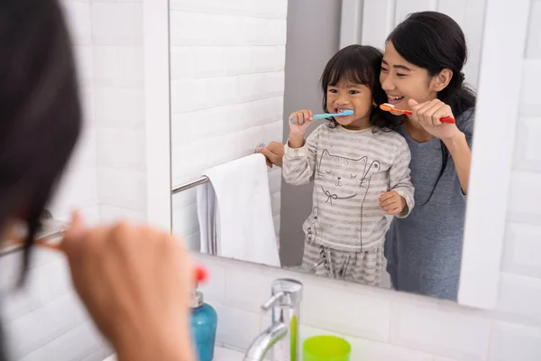 Madre e hija cepillándose los dientes en el lavabo del baño —  Fotos de Stock