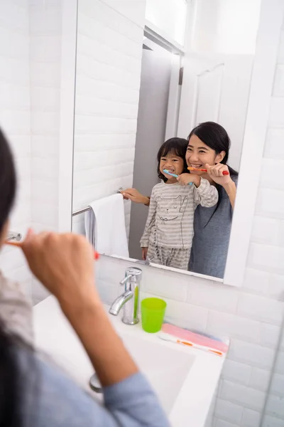 Madre e hija cepillándose los dientes en el lavabo del baño —  Fotos de Stock