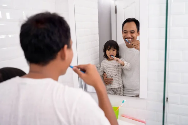 Papá y la chica se cepillan los dientes juntos —  Fotos de Stock