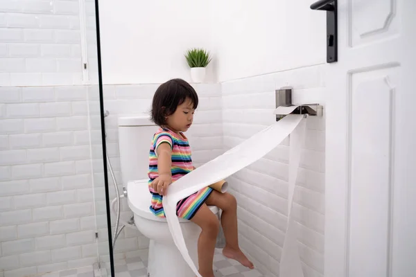 Малыш вытаскивает туалетную бумагу — стоковое фото