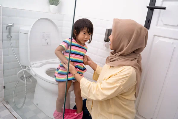 이슬람 어머니 화장실을 사용 하 여 그녀의 아이 도움 — 스톡 사진