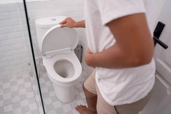 Man hold his stomach painful in the toilet — Stock Photo, Image