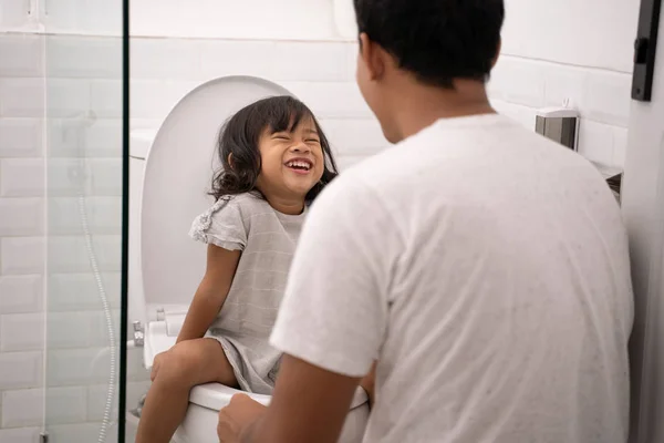 Отец научить ее дочь туалетной дорожки — стоковое фото