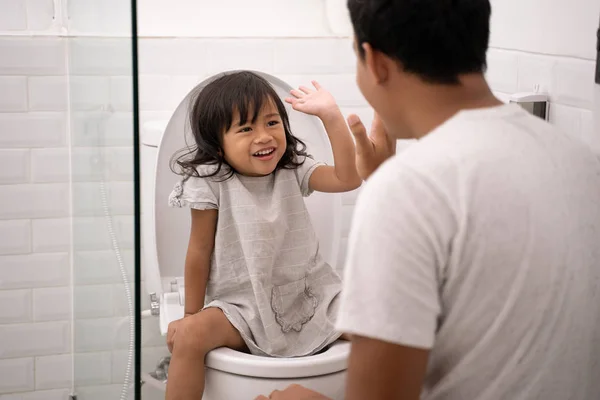 Oddler high five with her dad while toilet traning — Stock Photo, Image