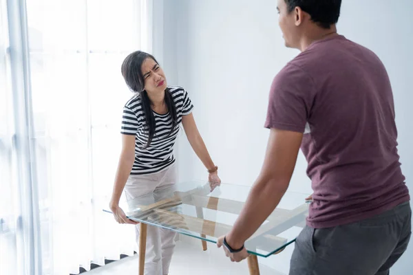 Um novo casal traz uma mesa e sua esposa sentiu muito pesado para levantar móveis — Fotografia de Stock