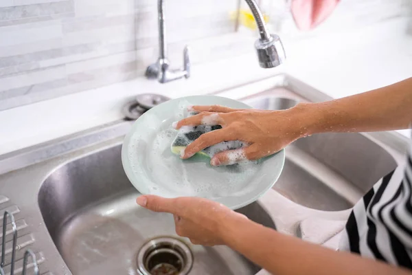 Female hand gesture cleaning plate using sponge — Stock Photo, Image