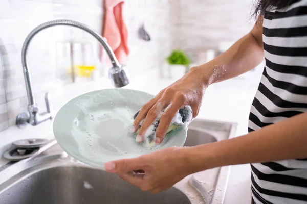 Hand wäscht einen Teller auf einer Spüle — Stockfoto