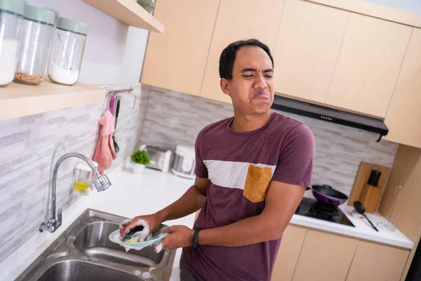 Homme malheureux tout en lavant la vaisselle — Photo