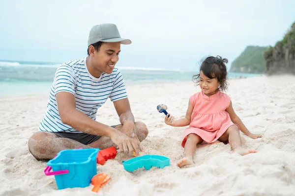 Отец с дочерью играют в песчаный замок — стоковое фото