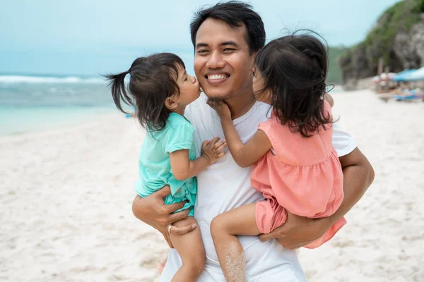 Dos niñita besándose juntos a su padre en la playa — Foto de Stock