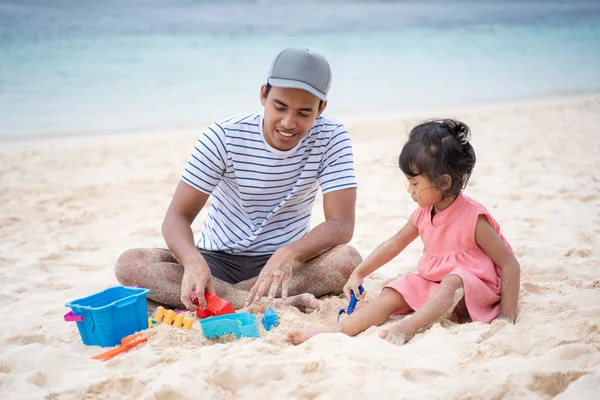 Pai e filha se divertindo sentados na areia branca da praia — Fotografia de Stock
