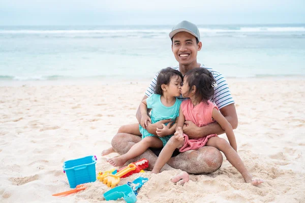 Felicidad de dos niñas besándose cuando en el regazo de papá — Foto de Stock