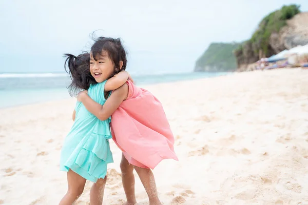 Retrato de dos niñas abrazándose en la playa —  Fotos de Stock