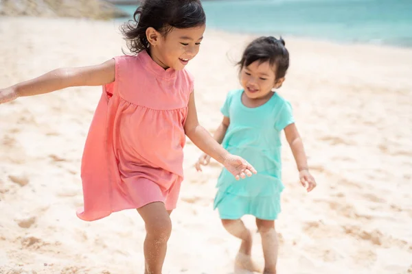 Children walking with hold hand together at the seashore — Stock Photo, Image