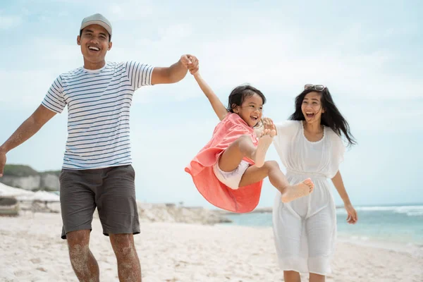 Retrato feliz família brincando na praia ao sol — Fotografia de Stock