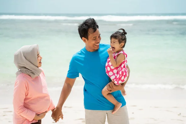Ayah, ibu, dan putrinya berjalan bersama dan bersantai di sekitar pantai — Stok Foto