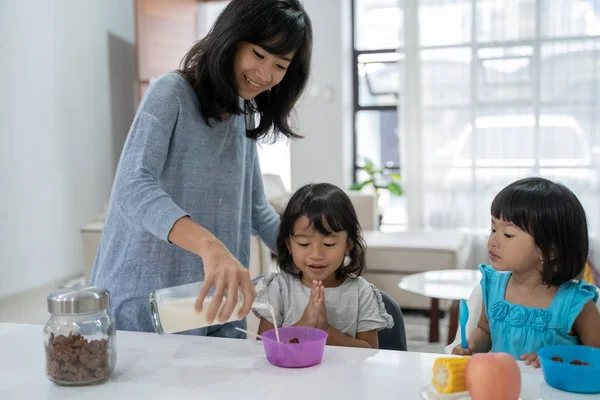 Madre preparando el desayuno para sus hijas — Foto de Stock