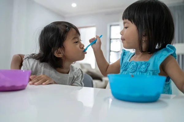 Bella ragazza fratello nutrirsi a vicenda in cucina — Foto Stock