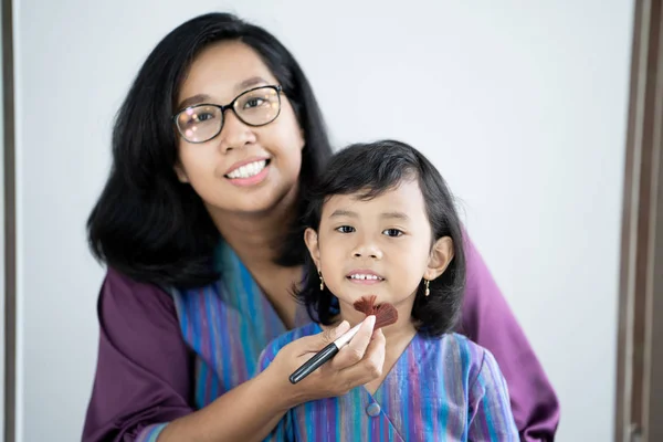 Moeder zet enkele make-up aan haar jonge meisje — Stockfoto