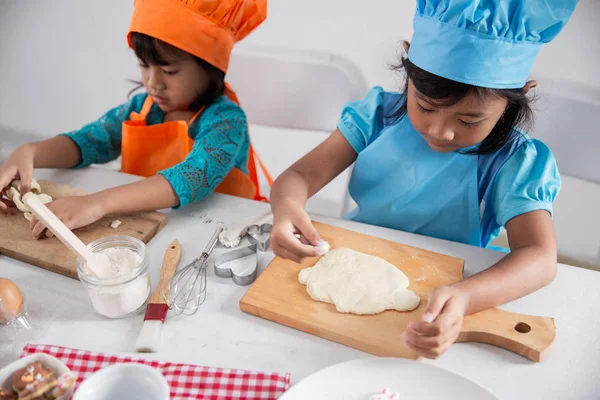 Две девочки малыша научиться готовить и сделать немного теста — стоковое фото