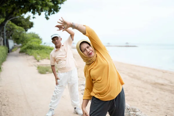Мусульманская старшая пара, занимающаяся растяжкой и упражнениями на открытом воздухе — стоковое фото