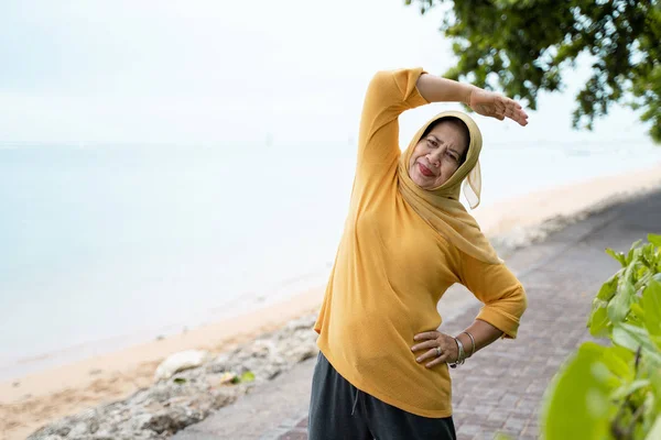 Muslim senior woman stretching and exercising outdoor — Stock Photo, Image